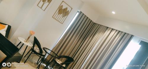 a room with a window with a curtain and chairs at Tambuli Resort Tower D in Lapu Lapu City