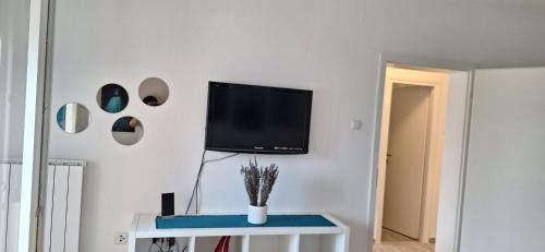 a living room with a tv on a white wall at Aurora with the view in Rijeka