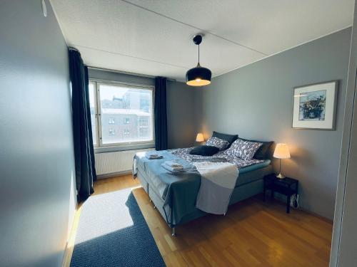um quarto com uma cama e uma janela em Ruoholahti Apartment with private sauna em Helsinque