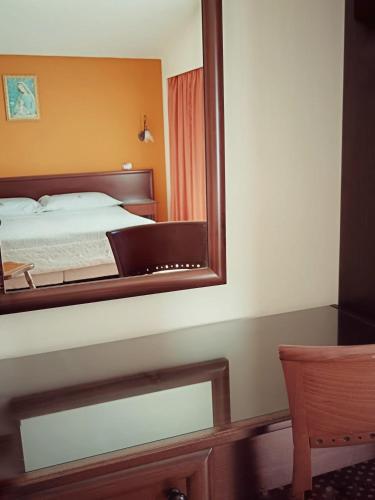 a mirror reflecting a bed in a bedroom at Villa Hirschen in Zafferana Etnea