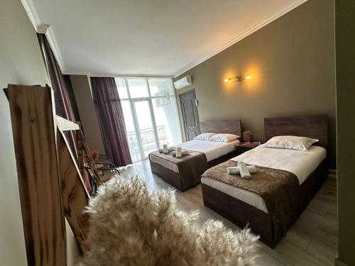 a hotel room with two beds and a large window at WoodSea in Batumi