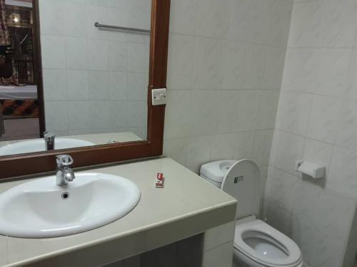 La salle de bains est pourvue d'un lavabo, de toilettes et d'un miroir. dans l'établissement Haven Resort, à Dar es Salaam