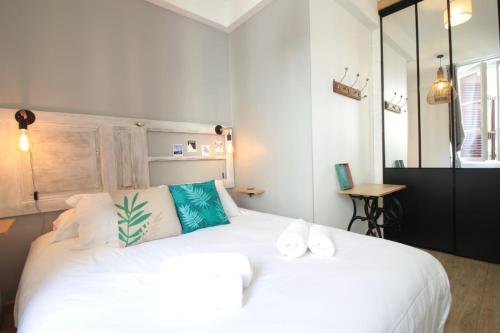 une chambre avec un grand lit blanc avec des oreillers bleus dans l'établissement L Annex centre ville Annecy, à Annecy