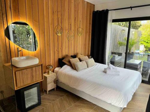 - une chambre avec un lit blanc et un lavabo dans l'établissement Le Petit Bonheur, à Les Ormes