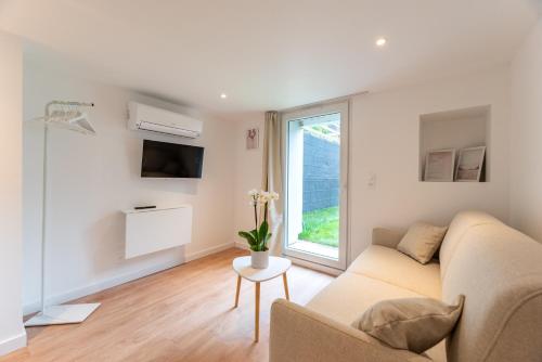 a living room with a couch and a window at Studios Le Médicis in Rouen