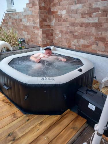 a man in a jacuzzi tub in a backyard at Ferienwohnung Hertha in Wernigerode