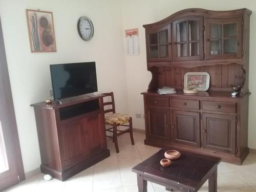 - un salon avec une télévision et une armoire en bois dans l'établissement Casa Lisa, à San Vito Lo Capo