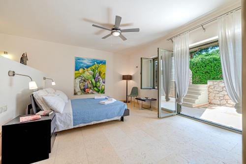 a bedroom with a bed and a ceiling fan at Costa Bianca Villas in Koilás