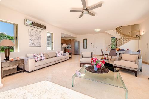 a living room with couches and a ceiling fan at Costa Bianca Villas in Koilás