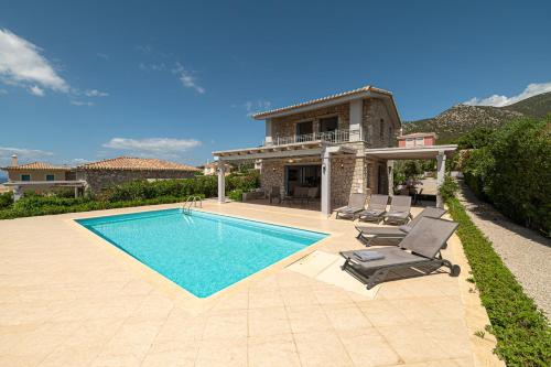 a house with a swimming pool in front of a house at Costa Bianca Villas in Koilás