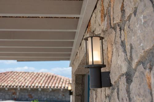 a light on the side of a stone wall at Costa Bianca Villas in Koilás
