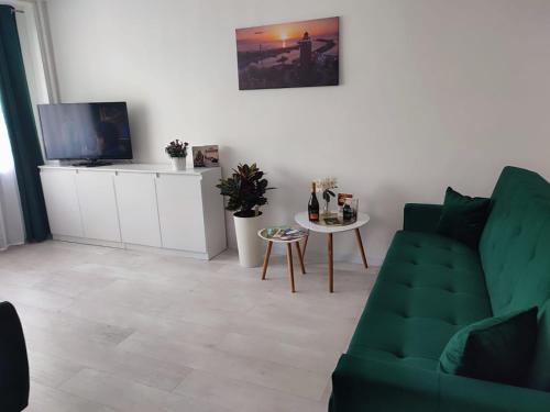 a living room with a green couch and a table at Kawalerka apartament ul gieldowa in Kołobrzeg