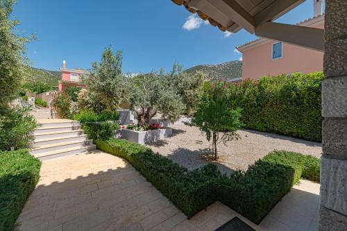 a garden with green hedges and a walkway at Costa Bianca Villas in Koilás