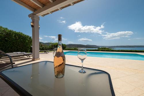 a bottle of wine and a glass sitting on a table at Costa Bianca Villas in Koilás