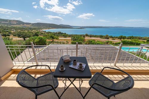 a table and chairs on a balcony with a view of the water at Costa Bianca Villas in Koilás