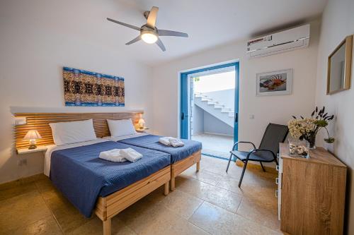 a bedroom with a bed and a ceiling fan at Costa Bianca Villas in Koilás