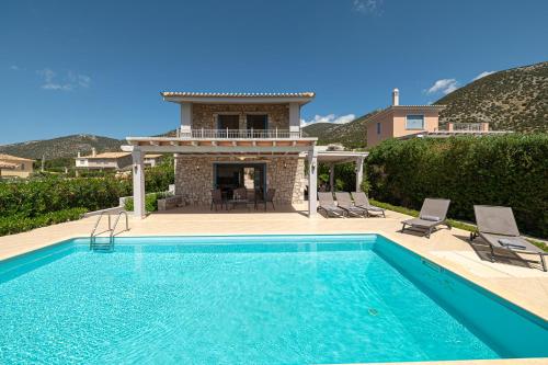 a swimming pool in front of a house at Costa Bianca Villas in Koilás