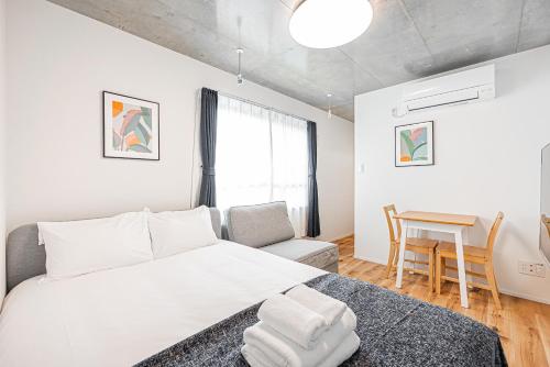 a bedroom with a bed and a table and a chair at 67 Apt 板橋本町 in Tokyo