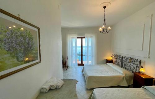 a bedroom with two beds and a painting on the wall at Residenza Porta di Mare in Castellabate