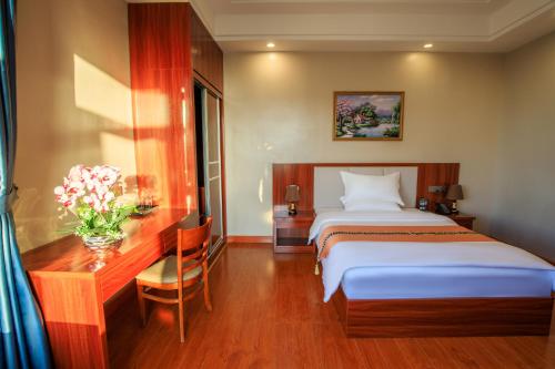 una camera d'albergo con letto, scrivania e letto Sidx Sidx. di Notis International Hotel 诺蒂斯国际酒店 a Phnom Penh