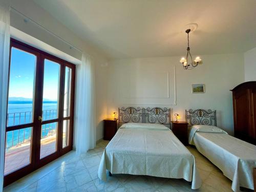 sypialnia z 2 łóżkami i dużym oknem w obiekcie Residenza Porta di Mare w mieście Castellabate