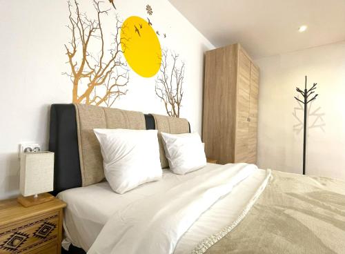 ブラショヴにあるSun Studio in Old Town Center - Quiet & Cozyの白いシーツのベッドと壁に黄色い顔が描かれた寝室