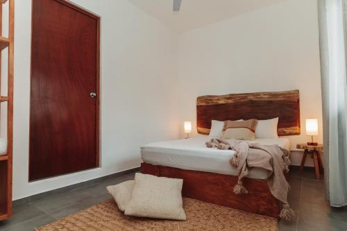 a bedroom with a bed with a wooden headboard at Che Zipolite Hostel & Naked Beach Club in Zipolite