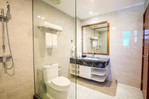 W łazience znajduje się toaleta i przeszklony prysznic. w obiekcie Notis International Hotel 诺蒂斯国际酒店 w mieście Phnom Penh