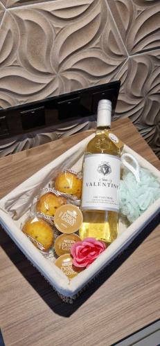 a bottle of whisky and some donuts in a tray at B8 Seaside Luxury Rooms with private bathroom - dining area shared in St Paul's Bay