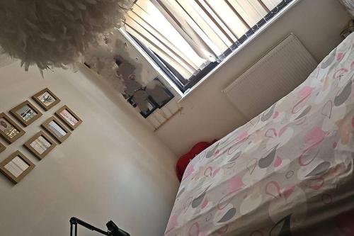a bedroom with a bed with pink sheets and a window at Cosy house close to London Bridge in London