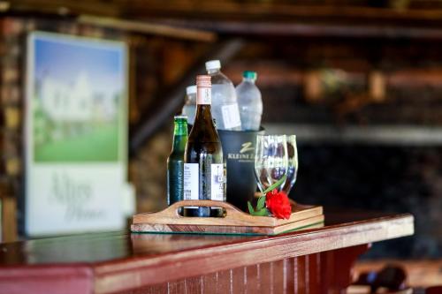 a table with bottles of wine and a wine glass at Altes Landhaus Country Lodge in Oudtshoorn