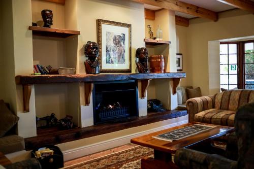 a living room with a fireplace and a couch at Altes Landhaus Country Lodge in Oudtshoorn