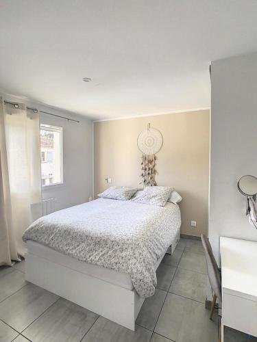 ein Schlafzimmer mit einem weißen Bett und einem Fenster in der Unterkunft Villa T4 avec Piscine et cuisine d'été in La Seyne-sur-Mer