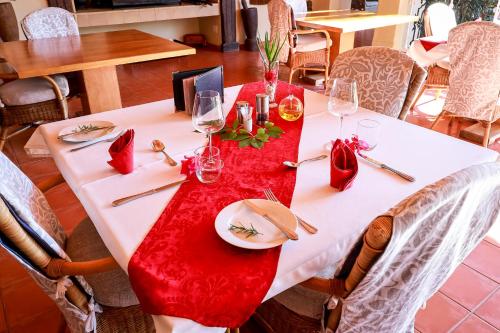 a table with a red and white table cloth on it at Altes Landhaus Country Lodge in Oudtshoorn