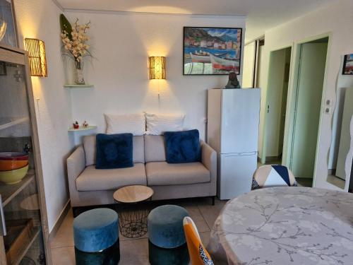ein Wohnzimmer mit einem Sofa und einem Kühlschrank in der Unterkunft Sopraland T3 45m2 à 300m plage Richelieu in Cap d'Agde