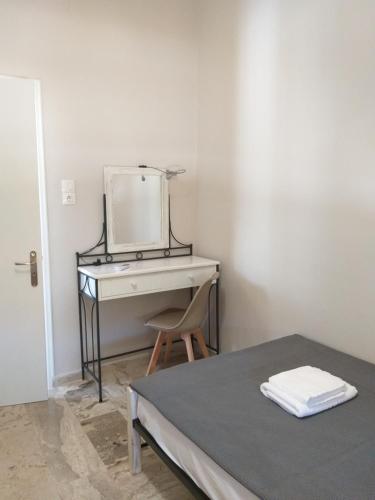 a bedroom with a bed and a desk with a mirror at Skala Central House in Skala