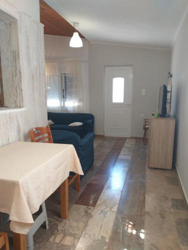 ein Wohnzimmer mit einem blauen Sofa und einem Tisch in der Unterkunft Skala Central House in Skala