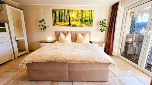 1 dormitorio con 1 cama y una pintura en la pared en Ferienwohnung Fasse im Solling - Natur hautnah erleben, en Uslar