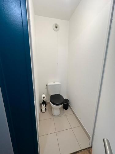 een kleine badkamer met een toilet met een zwarte stoel bij Le Blue Dream-Disney-Parking privé in Serris