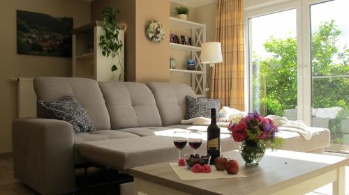 a living room with a couch and a table with wine glasses at Ferienwohnung Fasse im Solling - Natur hautnah erleben in Uslar