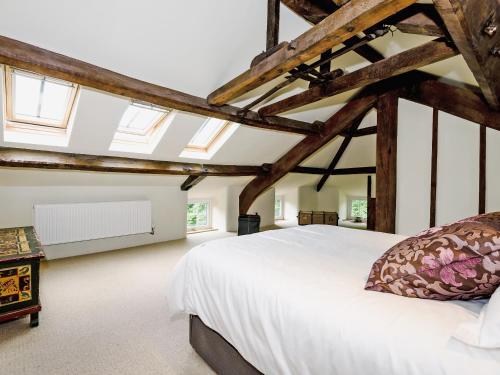 a bedroom with a large white bed and windows at The Old Mill in Hackthorpe