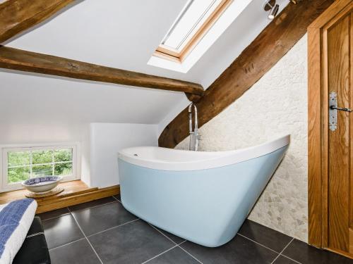 a bathtub in a bathroom with a vaulted ceiling at The Old Mill in Hackthorpe
