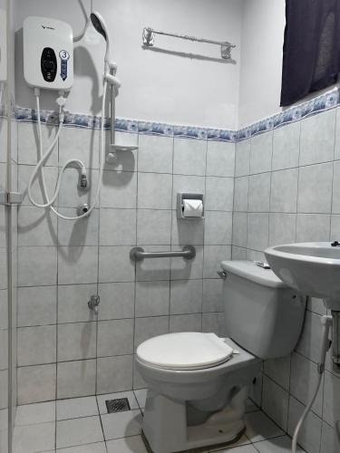 a bathroom with a shower and a toilet and a sink at LS Garden Villa in Puerto Princesa City