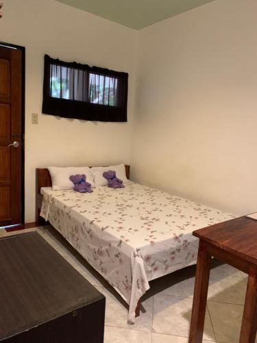 una camera da letto con un letto con cuscini viola e una finestra di LS Garden Villa a Città di Puerto Princesa