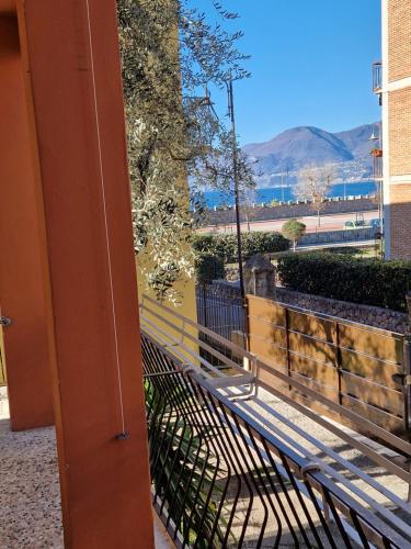 un banco en un balcón con vistas al agua en Casa rosario e annamaria, en Torri del Benaco
