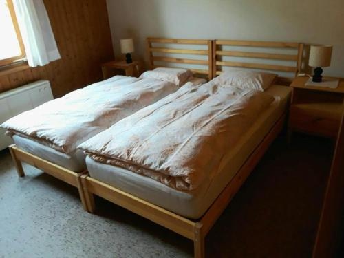 a bedroom with a large bed with a wooden headboard at Tanzhus in Wildhaus