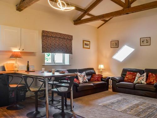a living room with a couch and a table at Barnby Barn 1 - Uk43808 in Bossall