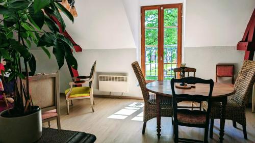 une salle à manger avec une table, des chaises et une plante dans l'établissement Emplacement exceptionnel au Coeur de l'Ile aux Pies, à Saint-Vincent-sur-Oust