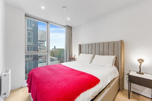 ein Schlafzimmer mit einem großen Fenster und einem Bett mit einer roten Decke in der Unterkunft The Becky Suite - Princes Dock Liverpool in Liverpool