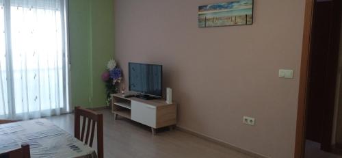 a living room with a flat screen tv on a cabinet at Bonito bajo cerca del mar in Benicarló